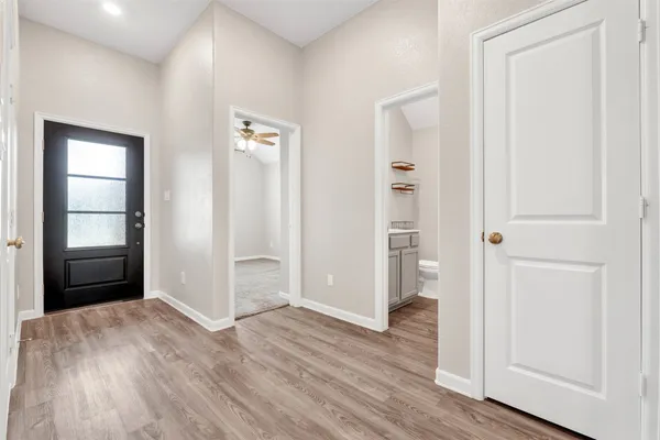 an empty room with wooden floor & closet and windows