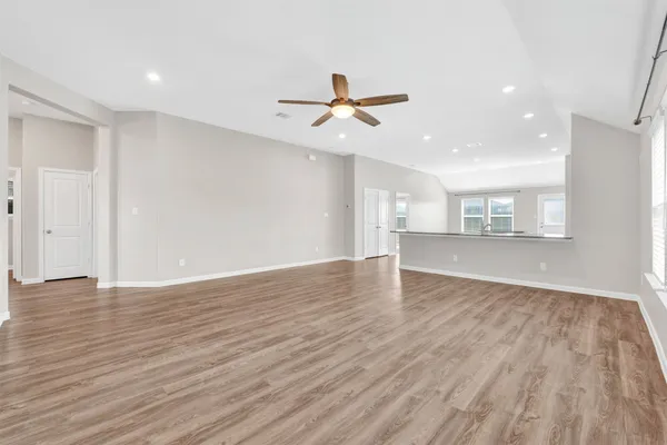 a view of a kitchen with wooden floor and a ceiling fan