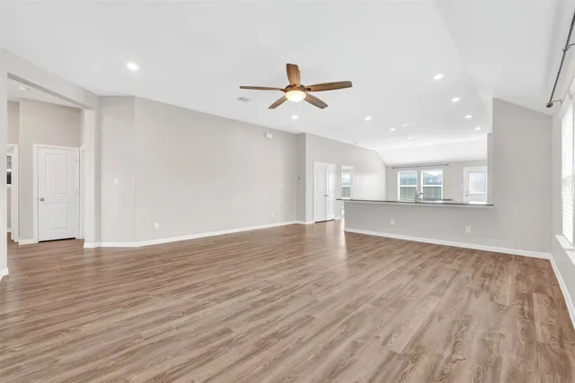 a view of a kitchen with wooden floor and a ceiling fan