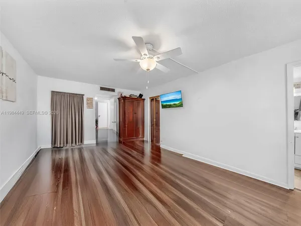 a view of an empty room with wooden floor