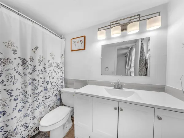 a bathroom with a sink a toilet and mirror