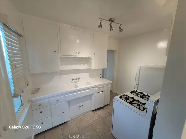 a kitchen with cabinets appliances and a window