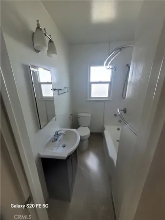 a bathroom with a sink a toilet and mirror