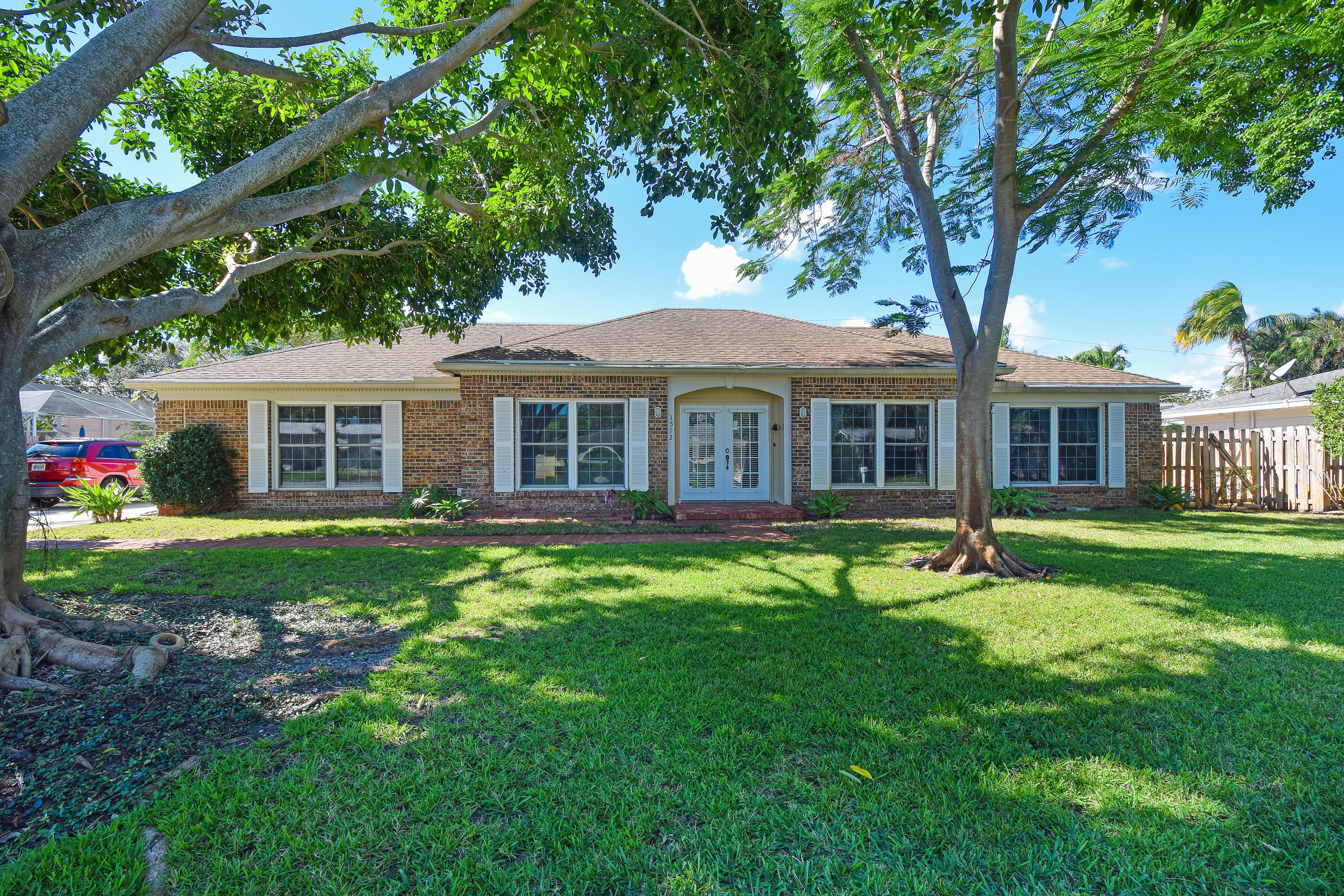 1512 Donald Road Jupiter, FL 33469 - Photo 7 of 57 a front view of a house with a garden