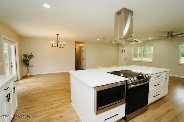 a kitchen that has a stove and a wooden floor