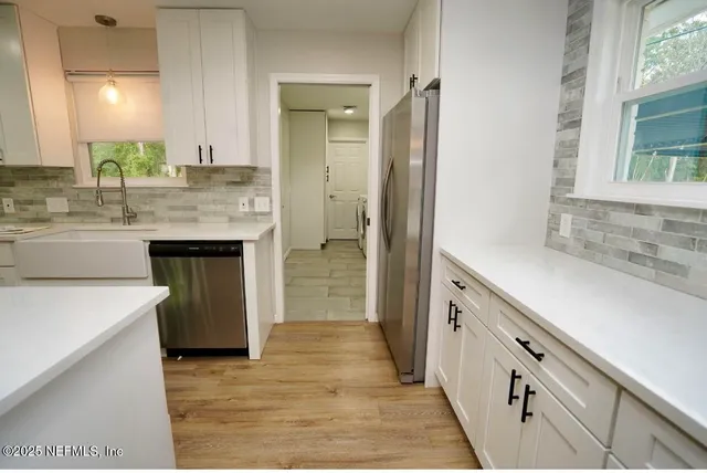 a kitchen with granite countertop a sink stove and refrigerator