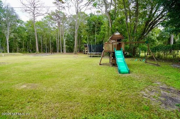 a backyard of a house with childrens swings and slides
