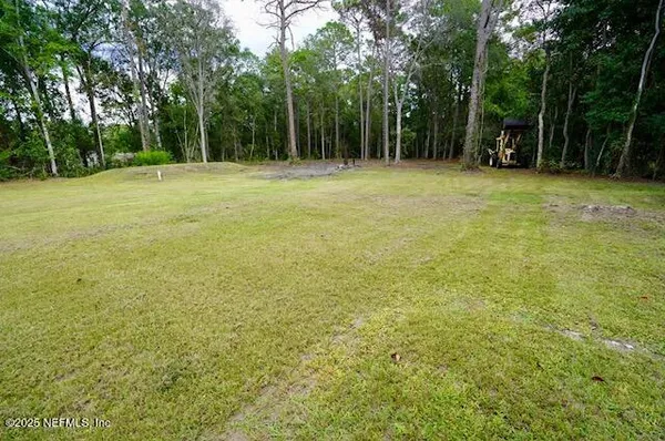 a view of a field with trees in the background