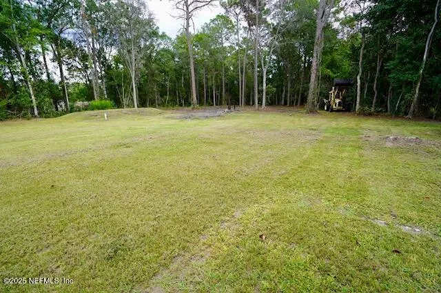 a view of a field with trees in the background