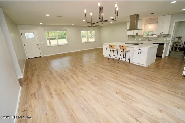 an open kitchen with granite countertop a stove top oven a sink and cabinets