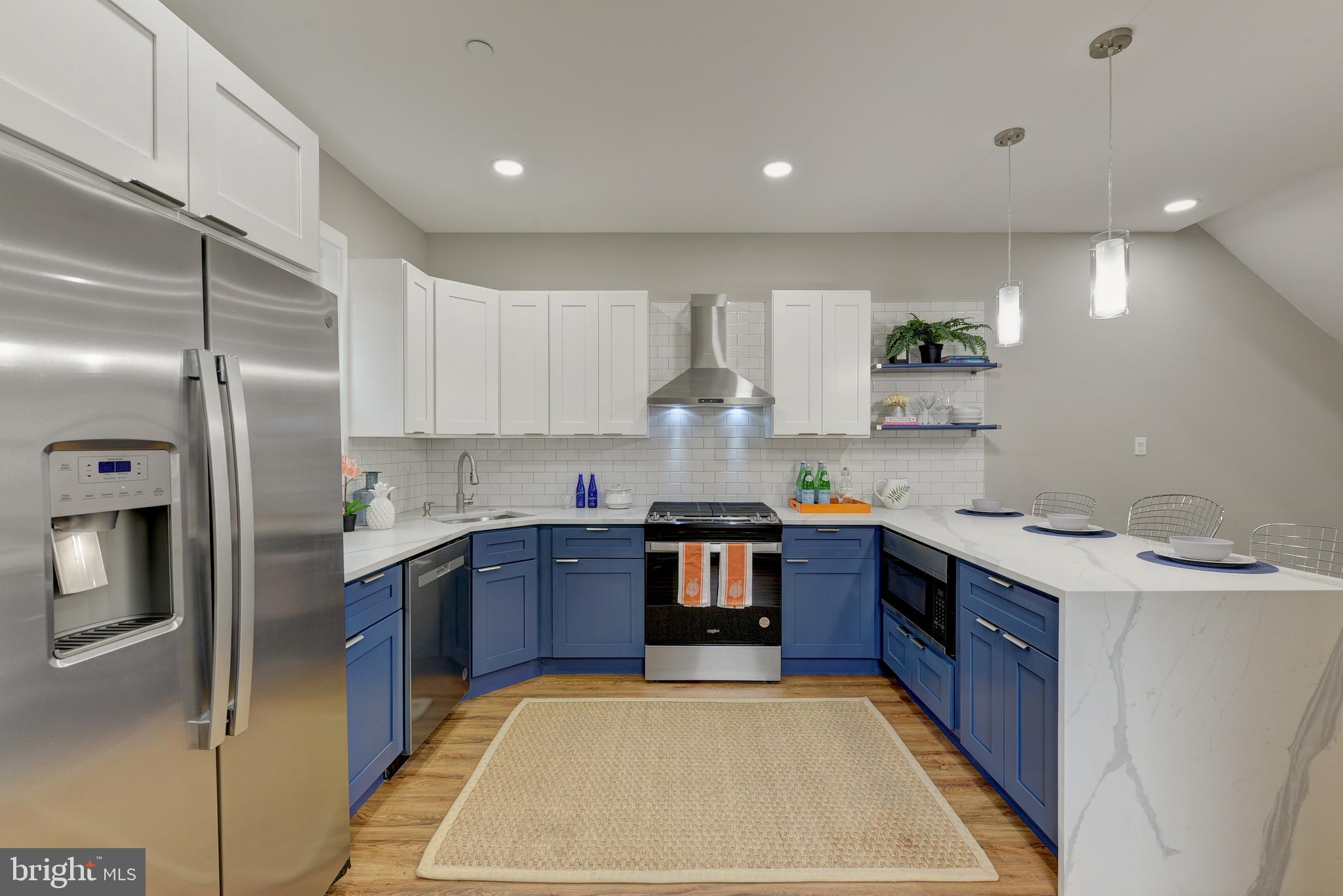 a large kitchen with stainless steel appliances granite countertop a stove refrigerator sink and cabinets