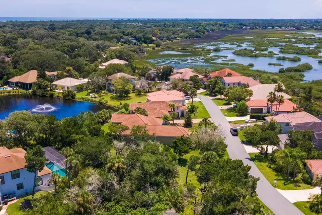 an aerial view of residential houses with outdoor space and river