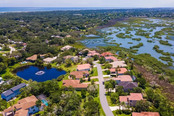 an aerial view of residential houses with outdoor space and trees