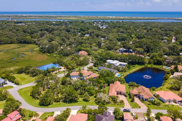 an aerial view of residential houses with outdoor space and trees
