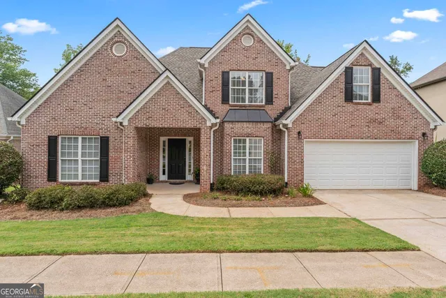 a front view of a house with a yard and garage