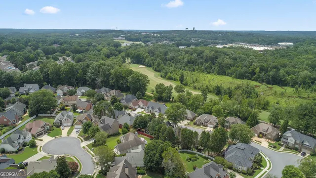 an aerial view of a houses with a yard and lake view