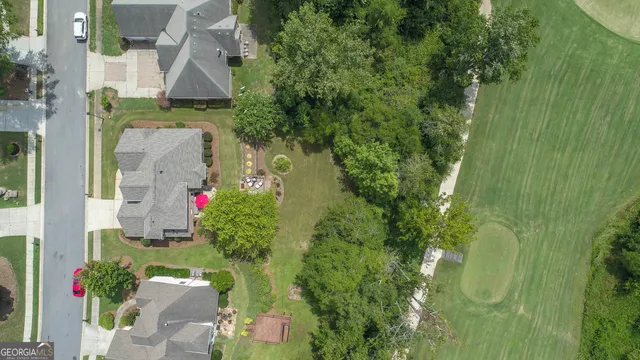 an aerial view of residential house with outdoor space and trees all around