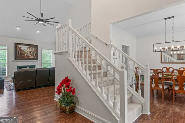 a living room with wooden floor and stairs