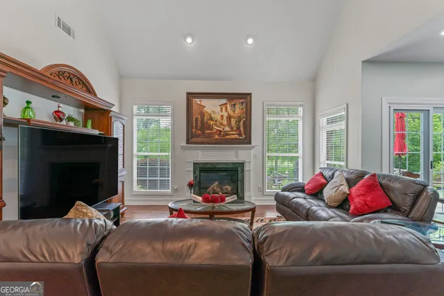 a living room with furniture large window and a fireplace