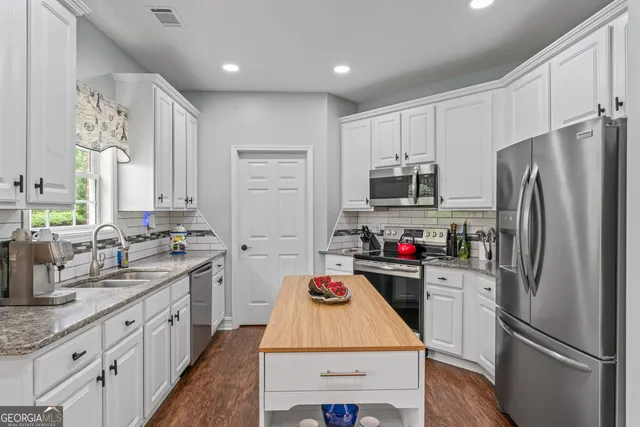 a kitchen with refrigerator a sink and microwave