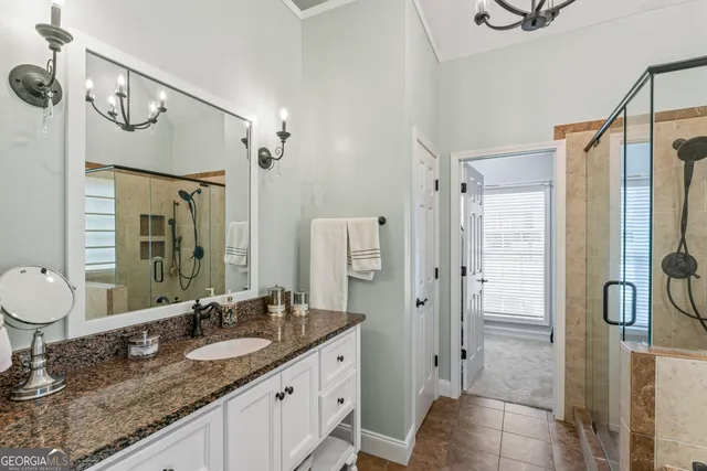 a bathroom with a granite countertop sink a mirror and shower