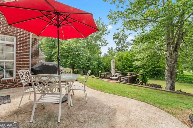 a view of a patio with a table and chairs under an umbrella