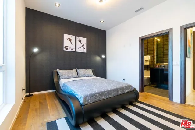 a bedroom with a bed and a lamp on dresser