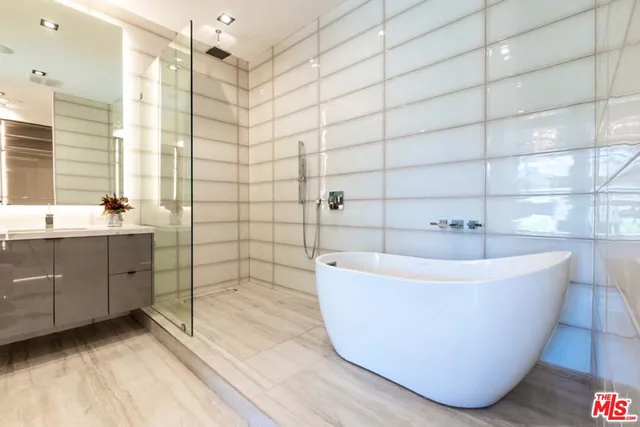 a white bath tub sitting in a bathroom and shower