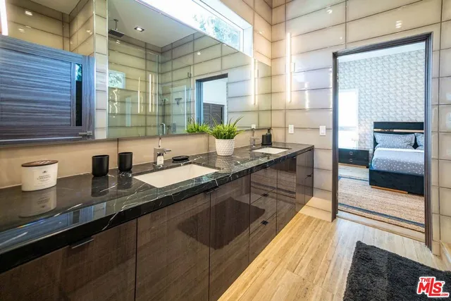 a kitchen with counter top space a sink wooden floor and glass door