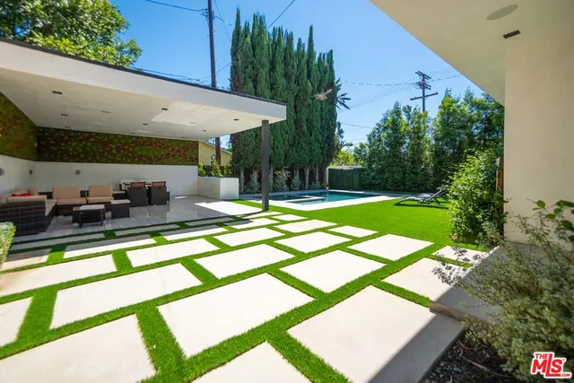 a view of a patio with a table and chairs under an umbrella