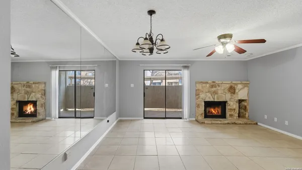a view of an empty room with a fireplace and window
