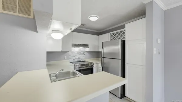 a kitchen with stainless steel appliances a refrigerator a stove a sink and a refrigerator
