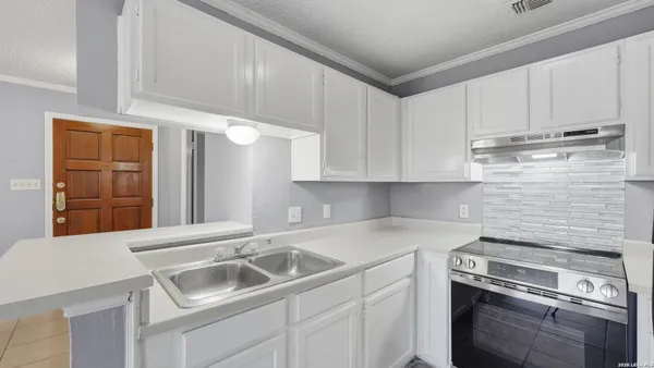 a kitchen with a sink cabinets and stainless steel appliances