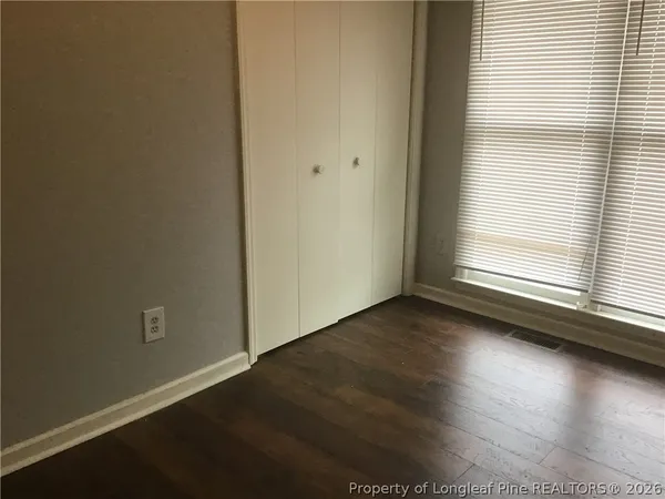 a view of a livingroom with wooden floor and a window