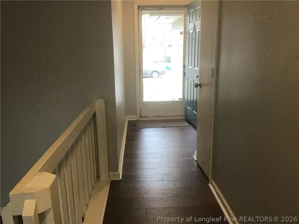 a view of hallway with stairs and wooden floor