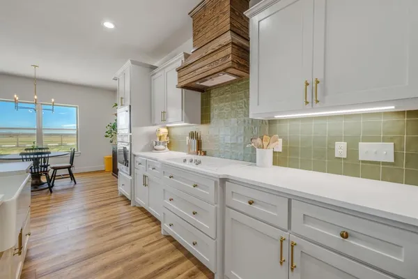 a large white kitchen with a stove a sink and a refrigerator