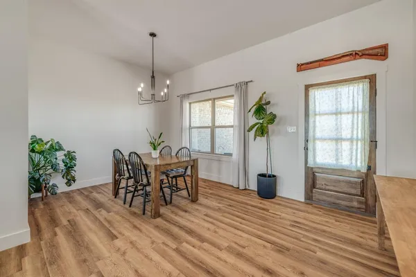 a dining room with furniture potted plants and wooden floor