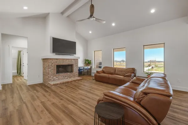 a living room with furniture a flat screen tv and a fireplace