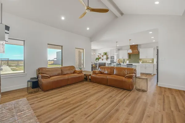 a living room with furniture and a wooden floor