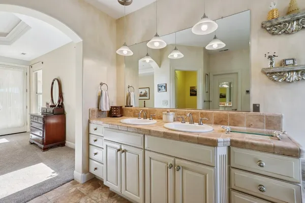 a spacious bathroom with a sink a mirror a bathtub and shower