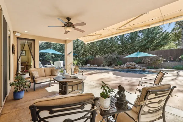 a view of a patio with a table and chairs under an umbrella