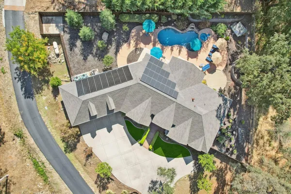 an aerial view of a house with a yard and mountain view in back