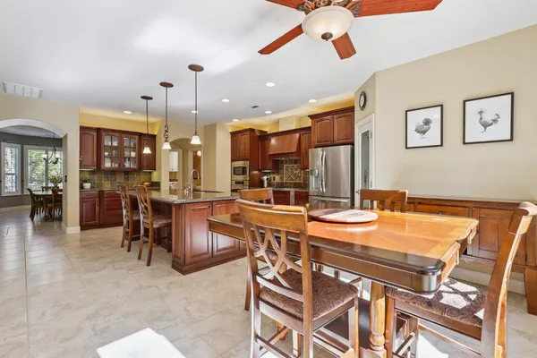 a dining room with stainless steel appliances kitchen island granite countertop furniture and a view of living room
