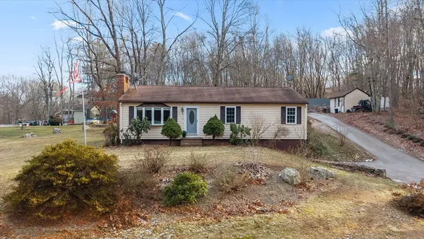 a view of a house with a yard and large tree