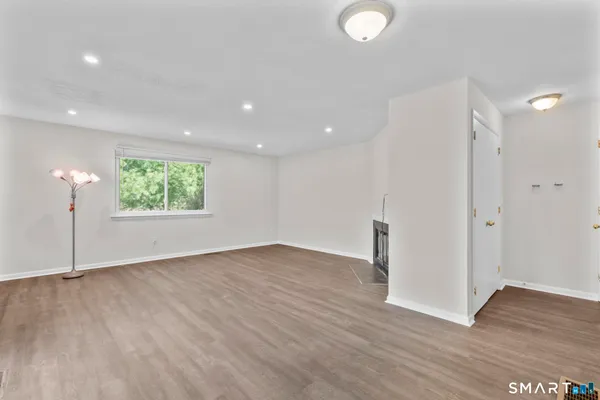 a view of a room with wooden floor and window