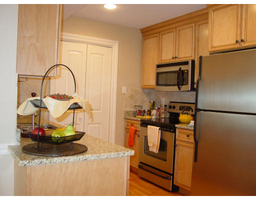 12 Russell Road, Unit 202 Wellesley, MA 02482 - Photo 5 of 15 a kitchen with a stove and a microwave