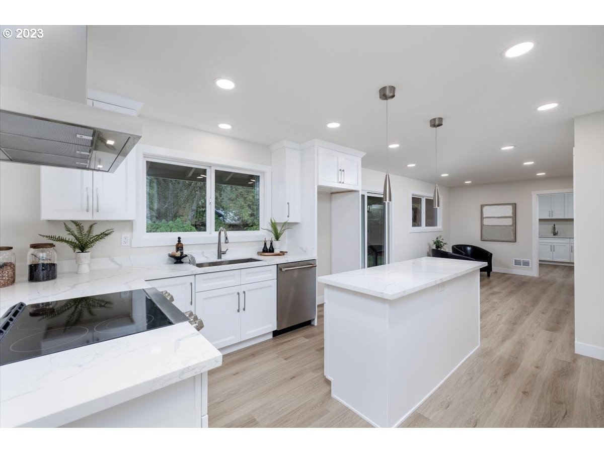 4011 Southwest 43rd Avenue Portland, OR 97221 - Photo 12 of 46 a large kitchen with stainless steel appliances kitchen island a sink a stove a refrigerator and white cabinets