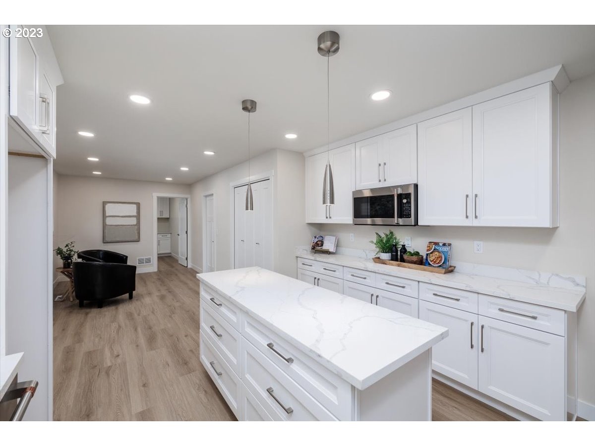 4011 Southwest 43rd Avenue Portland, OR 97221 - Photo 15 of 46 a kitchen with a sink a stove a refrigerator and white cabinets