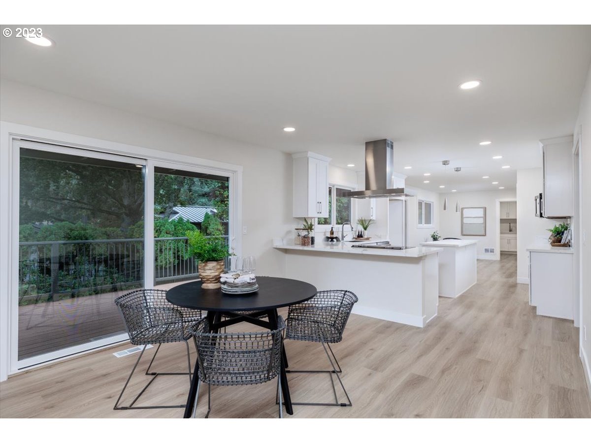 4011 Southwest 43rd Avenue Portland, OR 97221 - Photo 10 of 46 a kitchen with kitchen island a dining table chairs and white cabinets