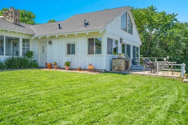 a view of a house with a yard and sitting area